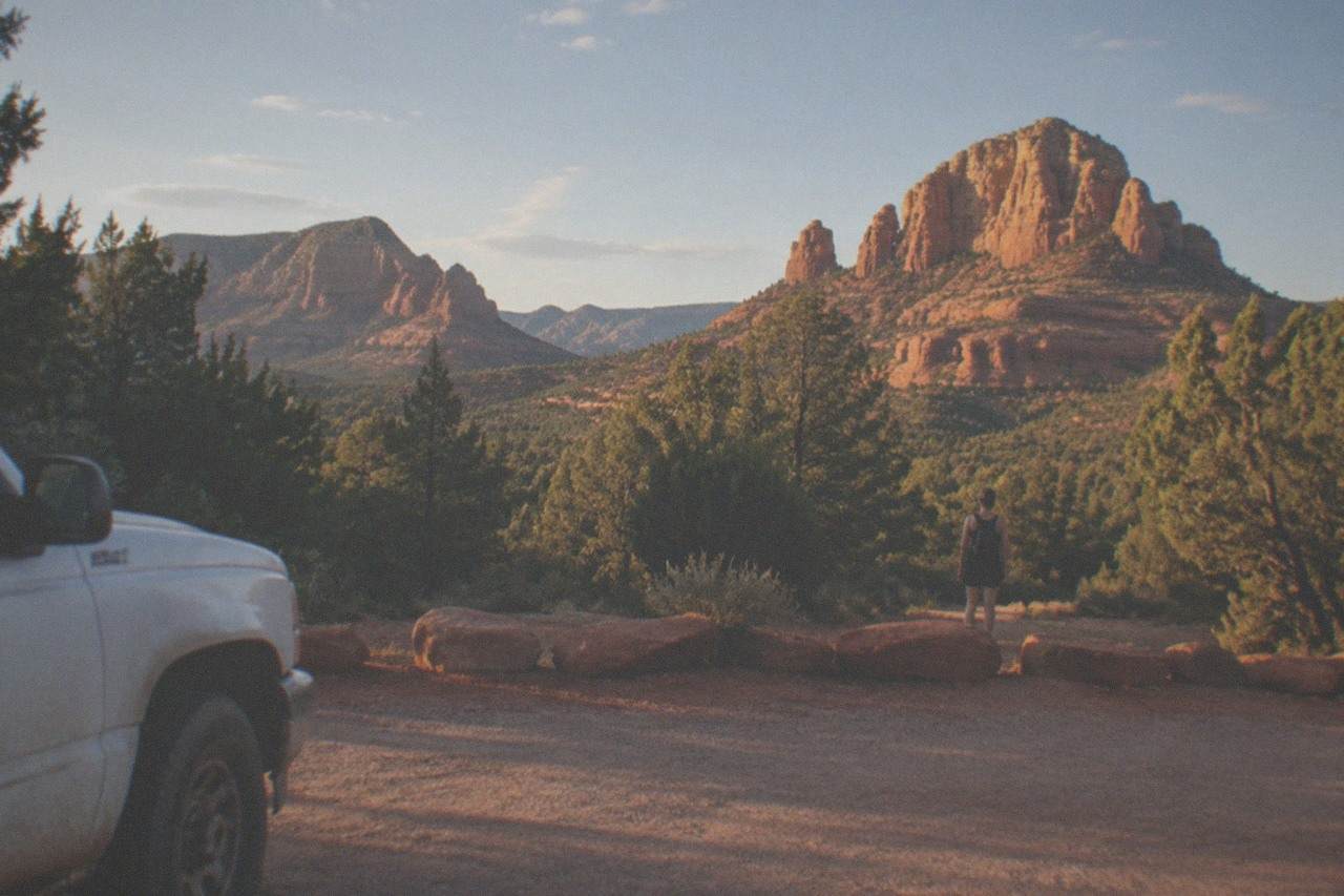 Red rock buttes rising above oak trees under a clear Arizona sky