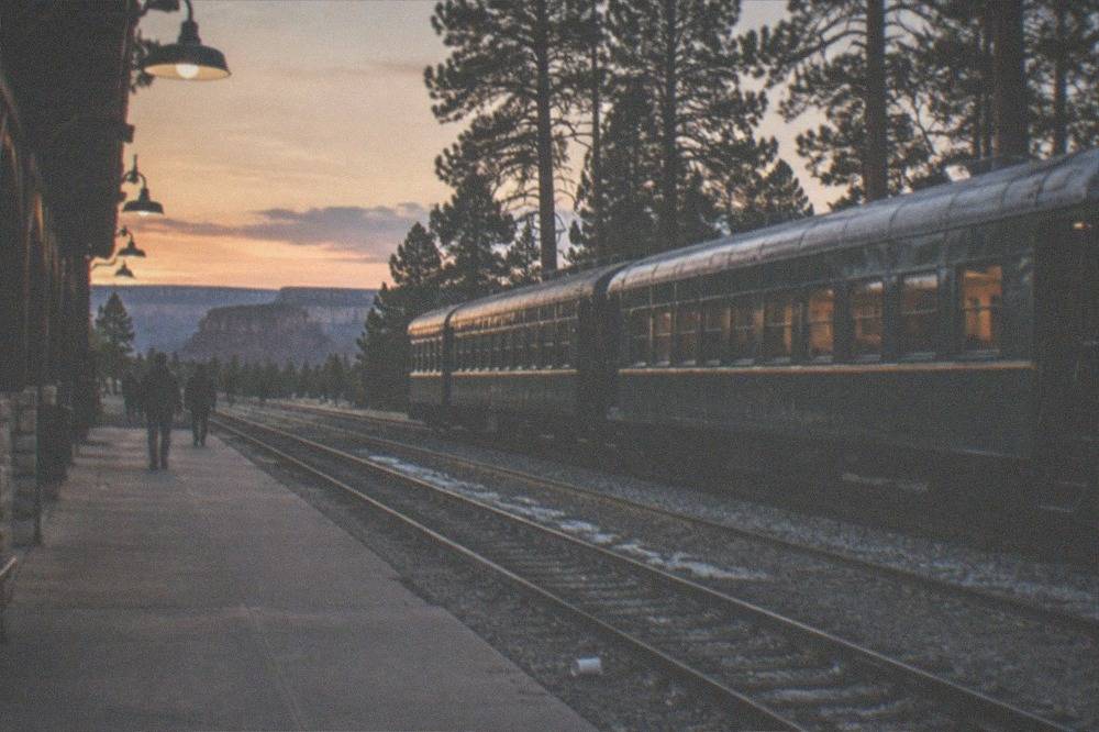 Railway platform in a small Arizona town with vintage passenger cars at dusk
