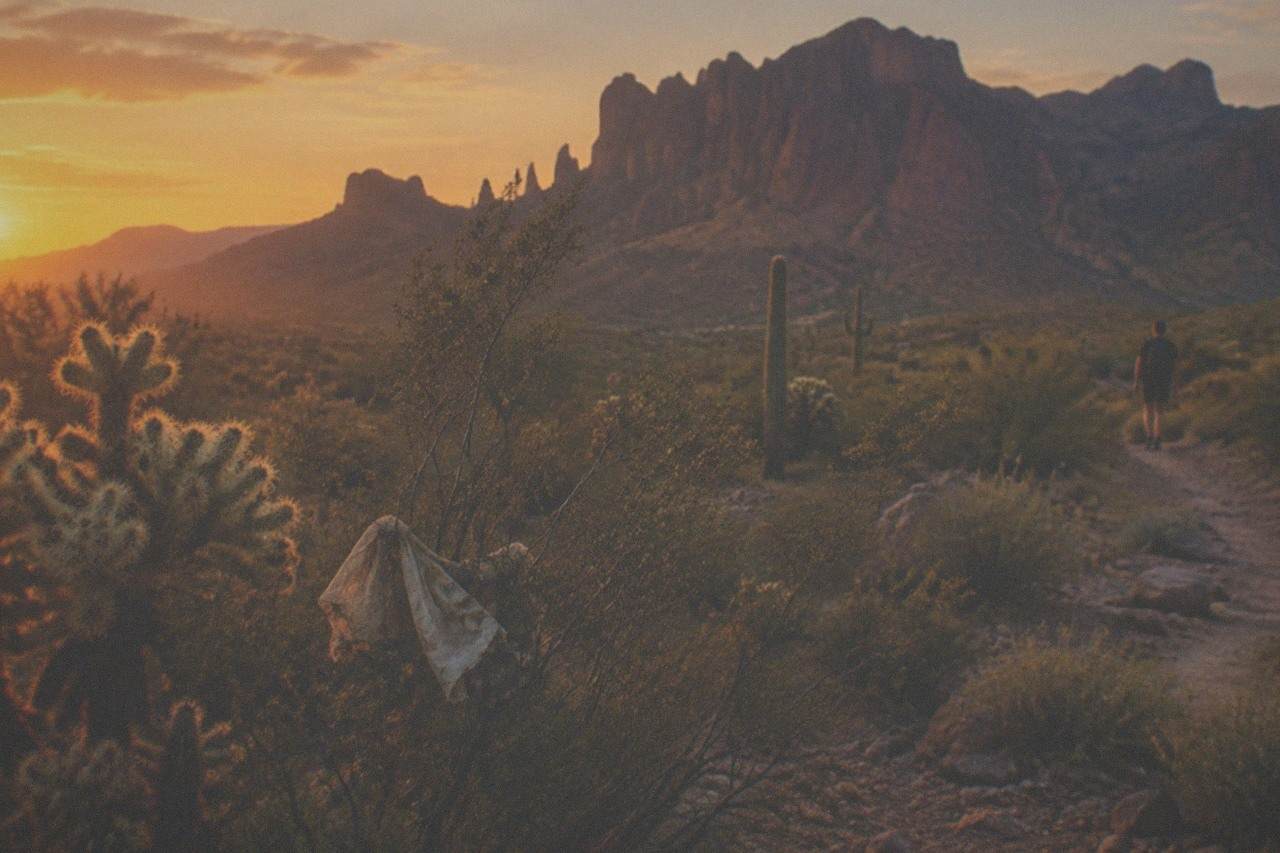 Red rock cliffs and desert hills under a wide Arizona sky