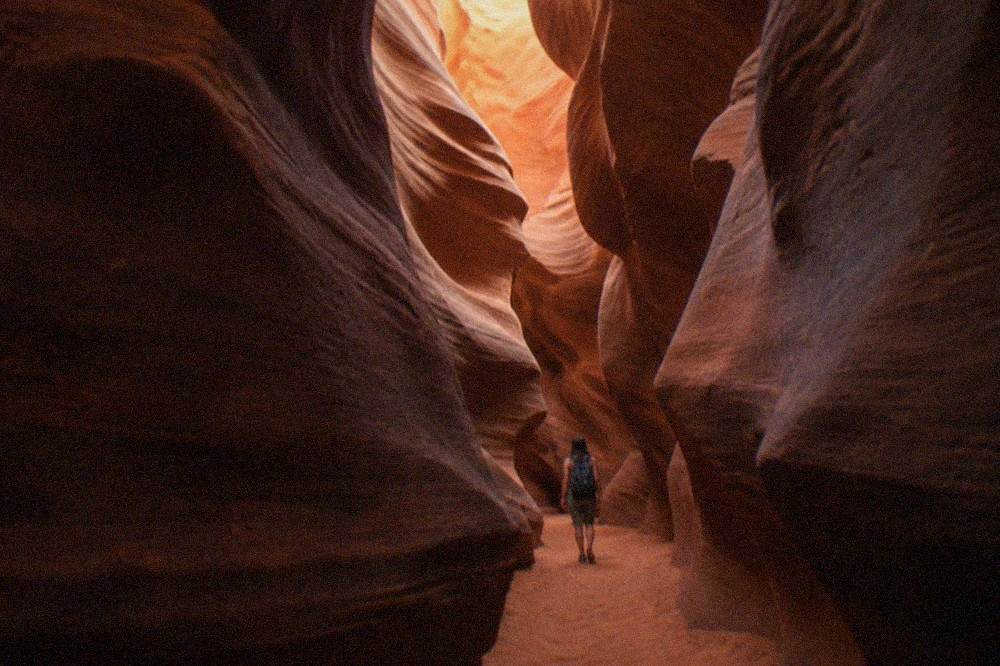 A narrow sandstone slot canyon with warm light on curved walls