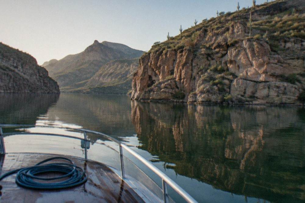 A steamboat cruising Canyon Lake between steep desert canyon walls
