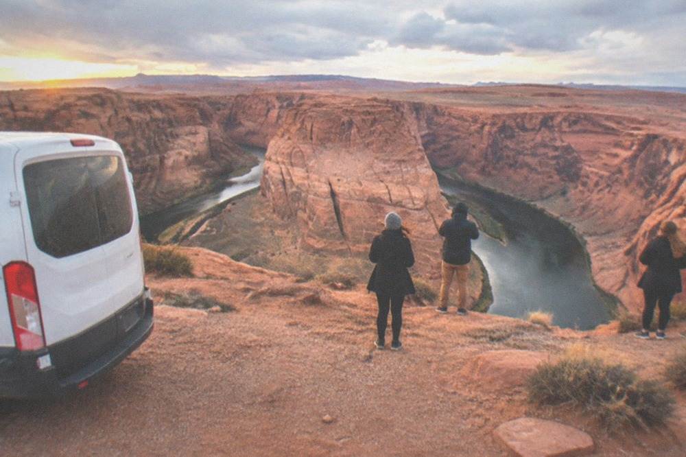 A tour van parked at a desert overlook above the Colorado River near Page