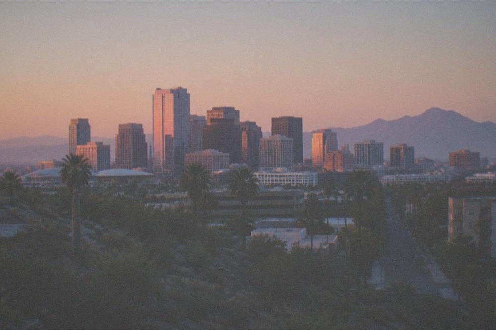 Phoenix skyline at dawn seen across the desert with distant mountains